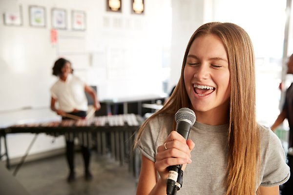 En flicka sjunger i mikrofon.